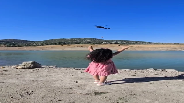 Yangına müdahale eden askeri helikopterin pilotu, kendisini selamlayan çocuğa el salladı